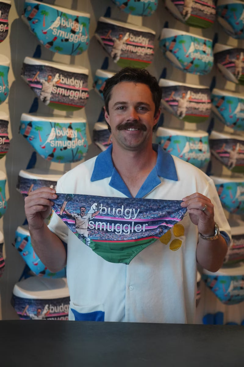 Man in a Budgy Smuggler store holding up The Head Masters smugglers