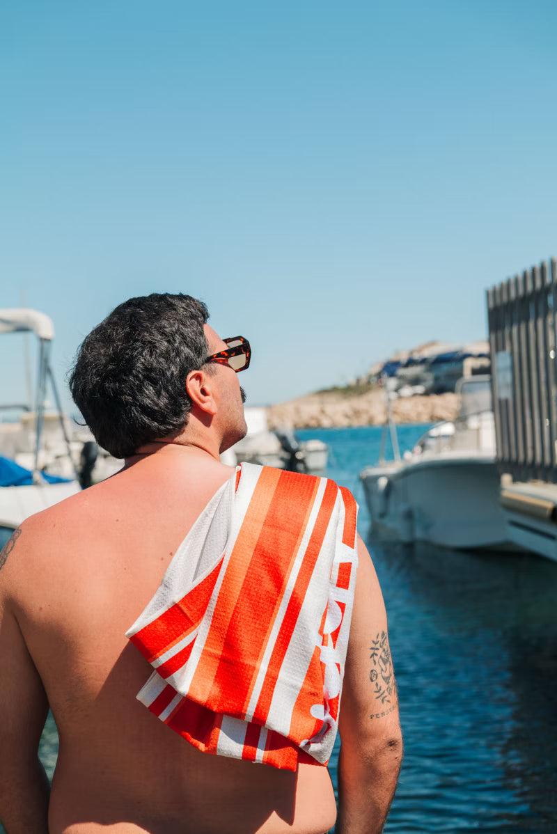Man using orange and white striped towel 