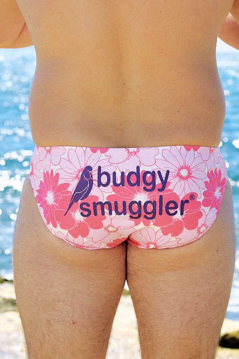 Back of the McGrath Foundation Floral smugglers, pink daisy print with purple logo, by the sea