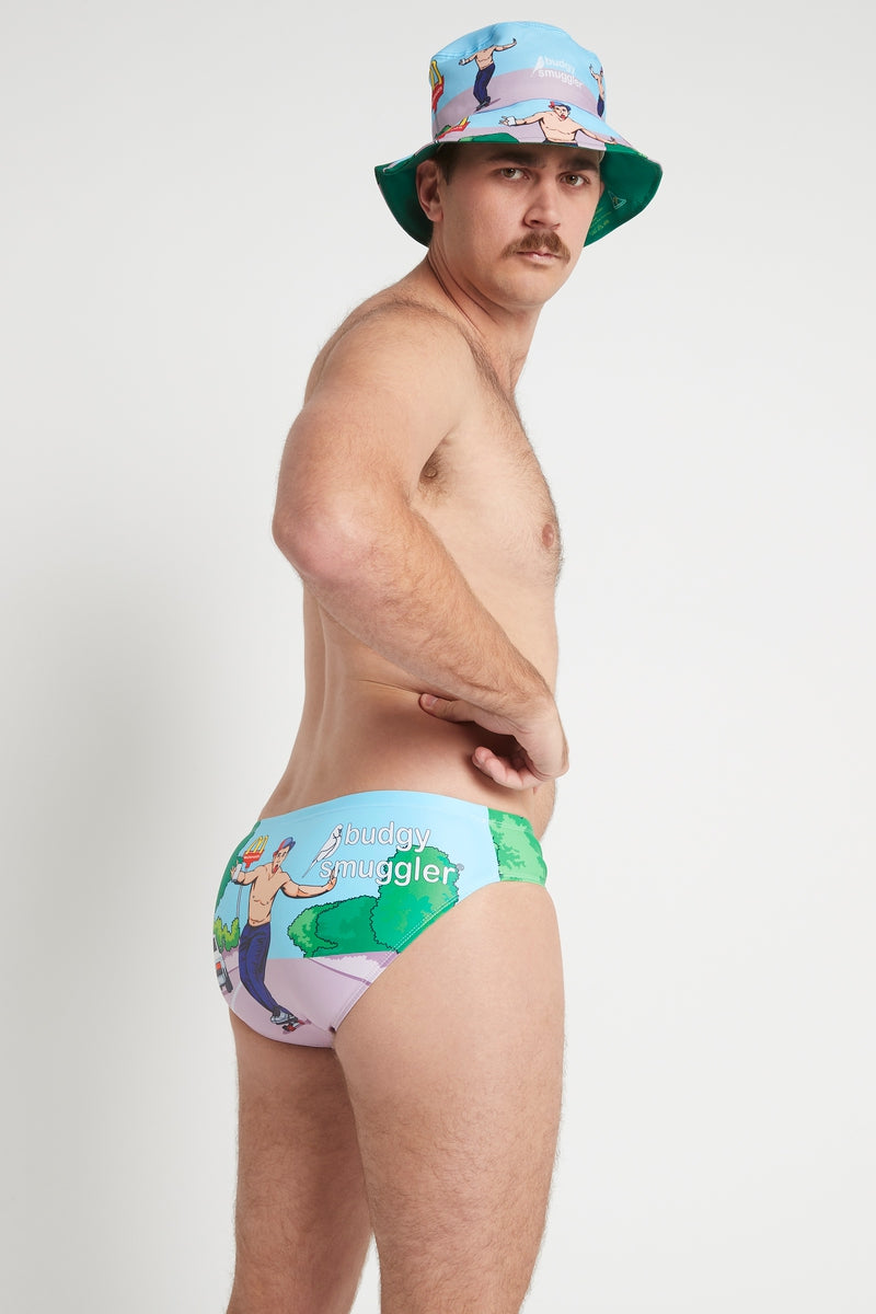 Side view of Immortal Smugglers men's swim briefs with blue sky and green trees print